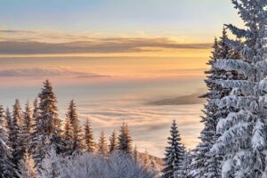 Snow covered landscape against colourful sky and cloud.